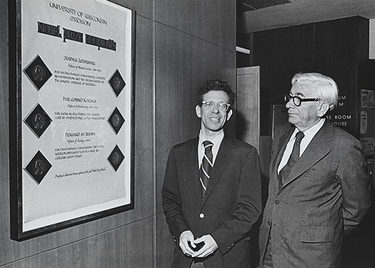Dr. Howard Temin (left) with President Edwin Young admiring Temin's Nobel Prize recipient plaque in the State Capitol building.